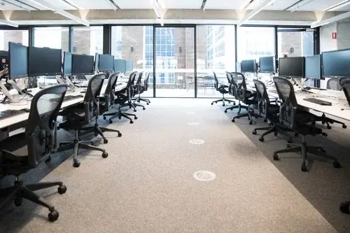 Imagem representando um imóvel comercial, sala de escritório com diversas cadeiras e computadores e uma bela vista